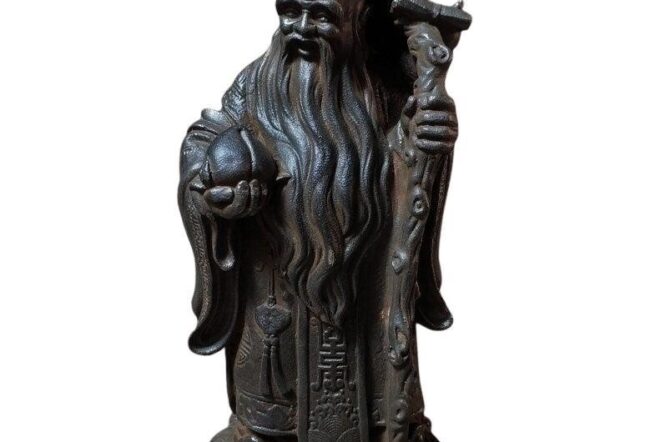 A detailed sculpture of a bearded figure holding a staff and a peach, possibly representing longevity or wisdom.